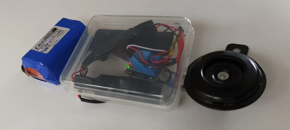 Prototype Bluetooth horn: battery pack, electronics in a clear plastic box, and a motorcycle horn