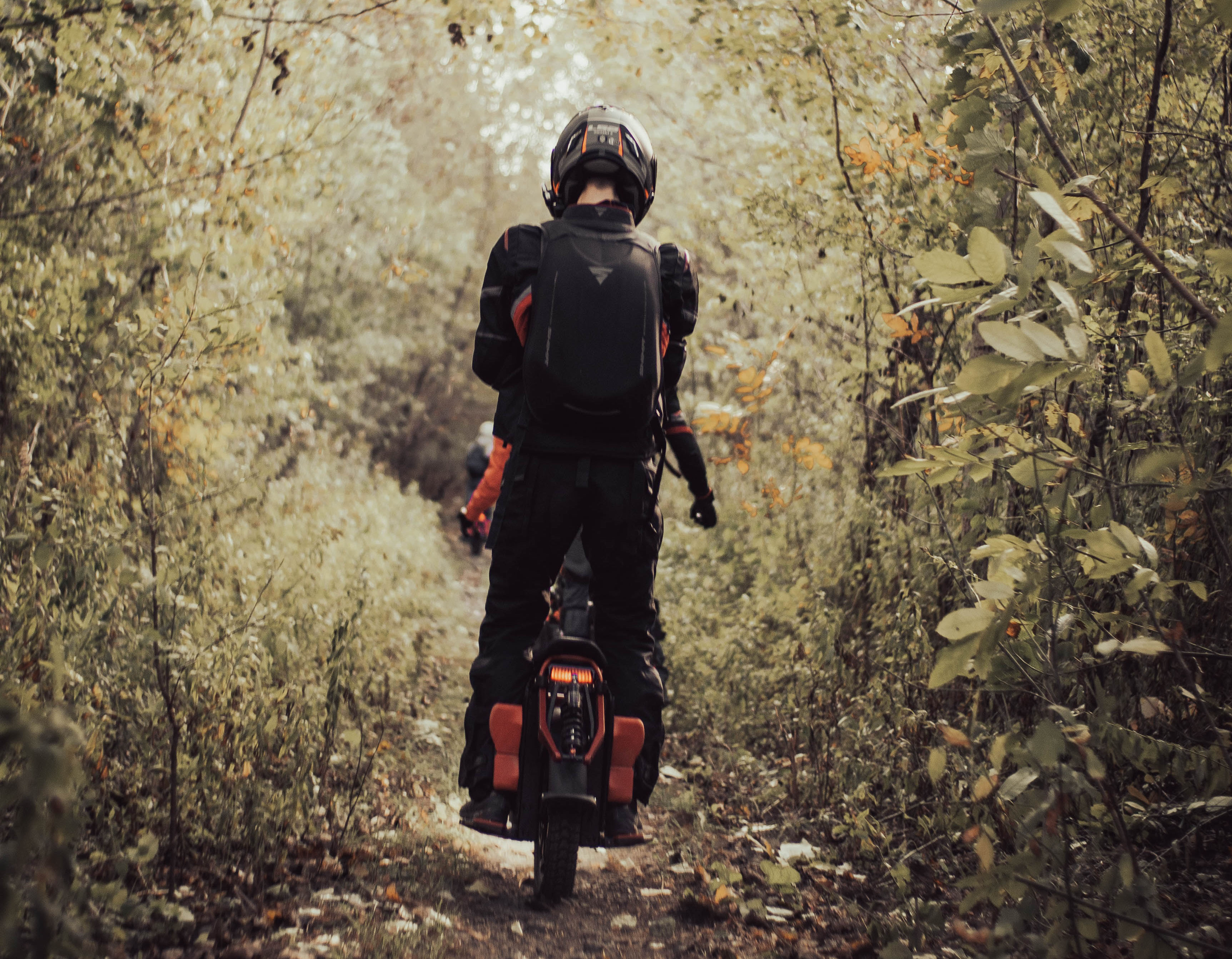 Electric unicycle rider on a wooded path